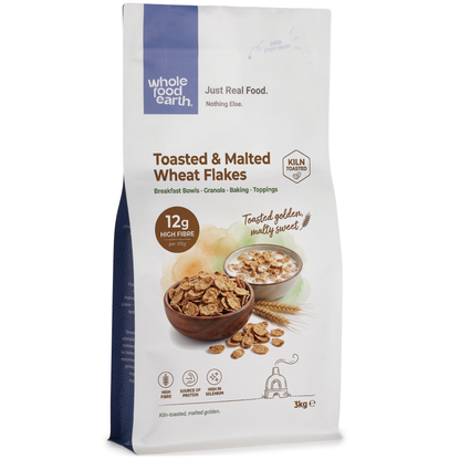 Whole Food Earth toasted and malted wheat flakes cereal in a bowl with milk, close-up view of crispy, golden grains.