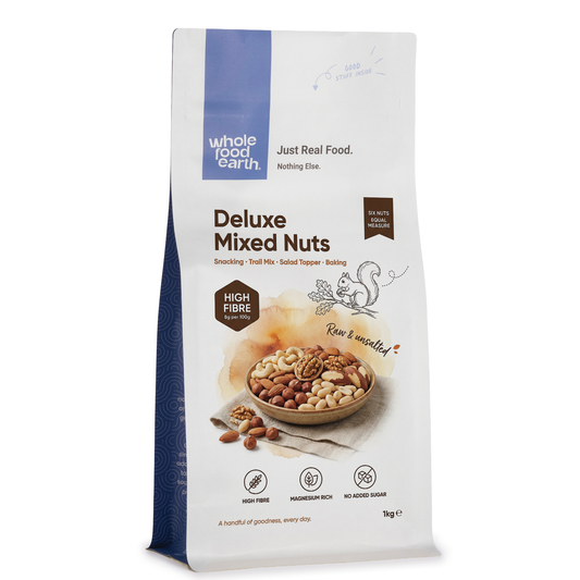 Assorted mixed nuts from ArtisanBox Deluxe Mixed Nuts package, featuring almonds, cashews, and pecans in a natural snack setting.