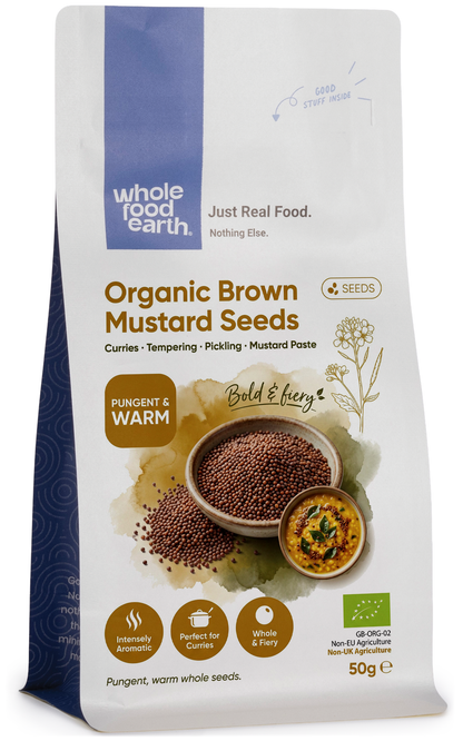 Organic brown mustard seeds in a clear jar, part of Whole Food Earth herbs and spices collection, on a wooden surface.