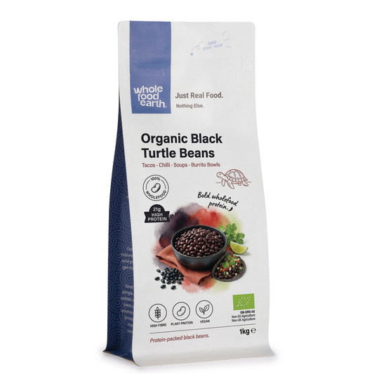 Organic black turtle beans from ArtisanBox, showing fresh, plump beans in a natural setting with a dark, shiny appearance.
