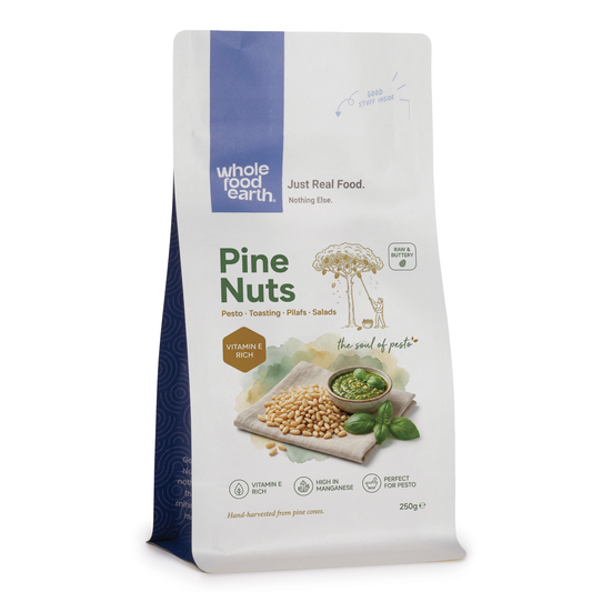 Whole Food Earth pine nuts in a clear bowl, showing small, oval-shaped nuts with light beige shells from Nuts & Seeds category.