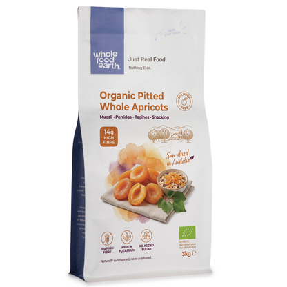 Organic dried pitted apricots from Whole Food Earth, showing shiny, orange whole apricots with smooth surfaces and natural texture.