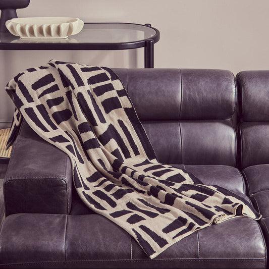 Natural and black throw by Orsina, showcasing a soft woven design for cozy home decor