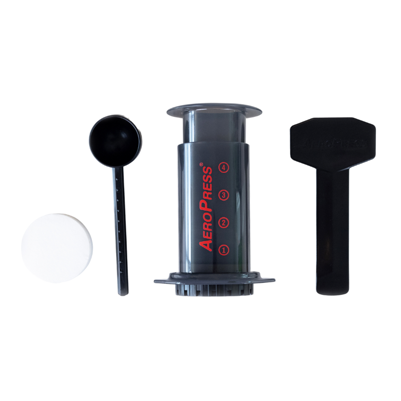 AeroPress Travel Coffee Maker from Contact Coffee Company Ltd. shown with brewing components on a wooden surface.