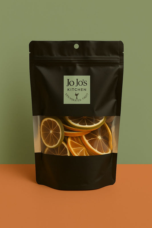 Assorted citrus fruits in a bowl, including oranges, lemons, and limes, from JoJo’s Kitchen Citrus Mix collection.