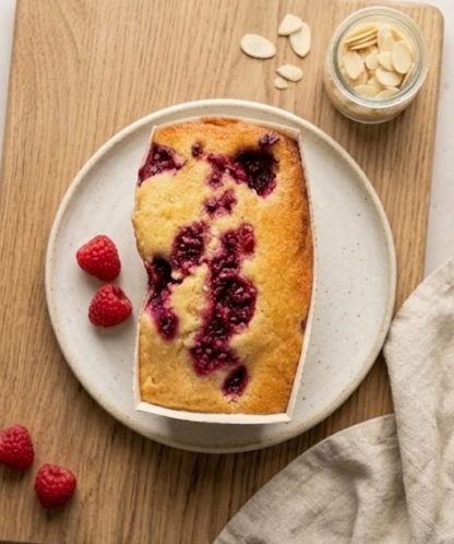 Raspberry Bakewell free from cake by The Healthy Cake Company, showcasing a sliced almond and raspberry cake on a plate.