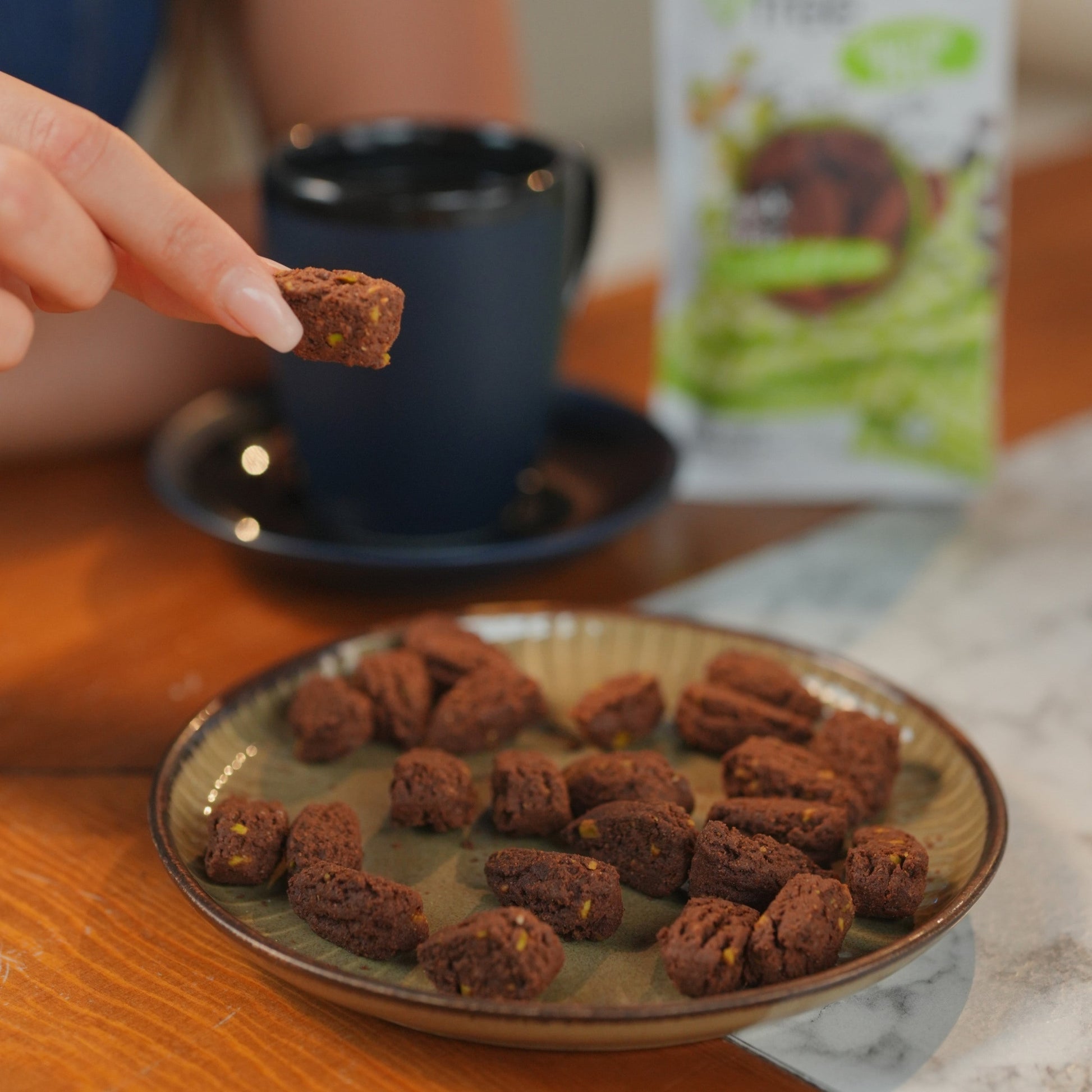 EverFree gluten-free pistachio and cocoa cookie on a white surface, showcasing the crunchy texture and nutty chocolate flavor.