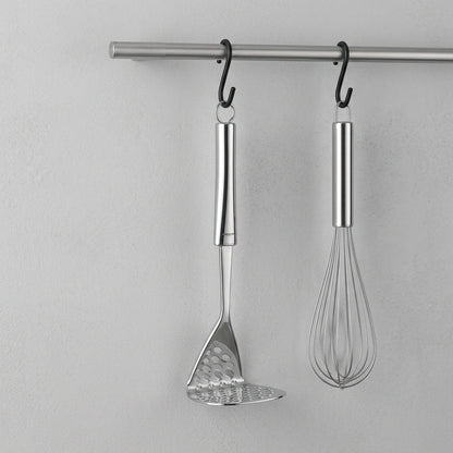 Glassware UK smart potato masher from Ghidini, kitchen utensil with ergonomic handle used for mashing potatoes in a modern kitchen setting.