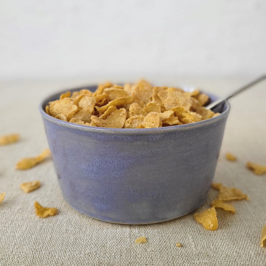 Amethyst purple breakfast bowl by Katie L Thompson Designs with cereal and spoon, showcasing a stylish ceramic bowl for breakfast.