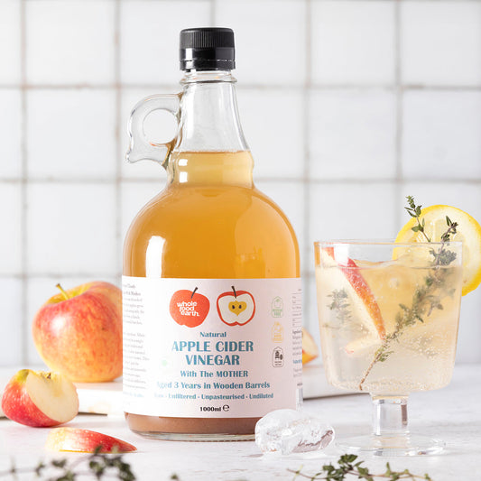 Whole Food Earth Kent Apple Cider Vinegar 2L with "Mother" bottles, raw, unpasteurized, unfiltered, GMO-free, on a kitchen counter.