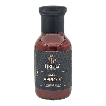 Sweet apricot BBQ sauce in a glass jar with a label, showcasing vibrant orange color and smooth texture from FireFly Barbecue.