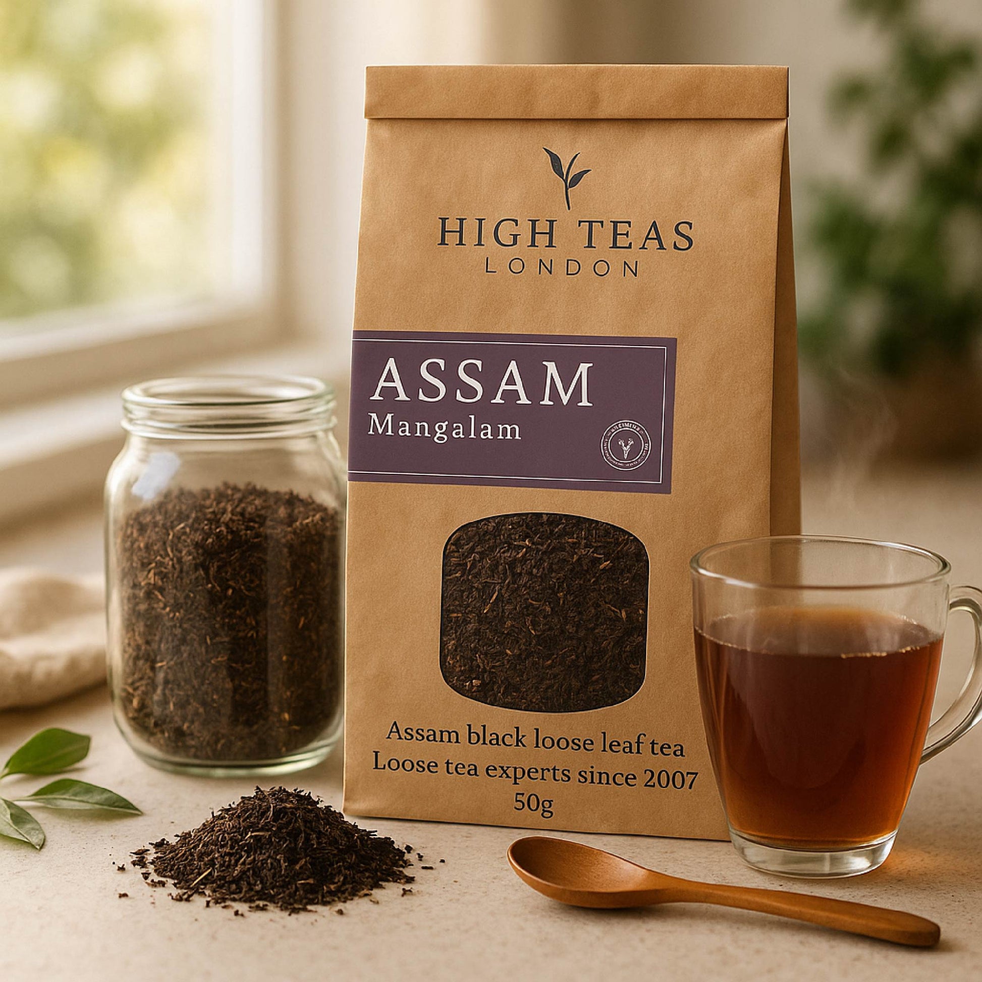 Assam Mangalam FTGFOP1 tea leaves in a tin with a cup of brewed Assam Mangalam tea on a wooden table.