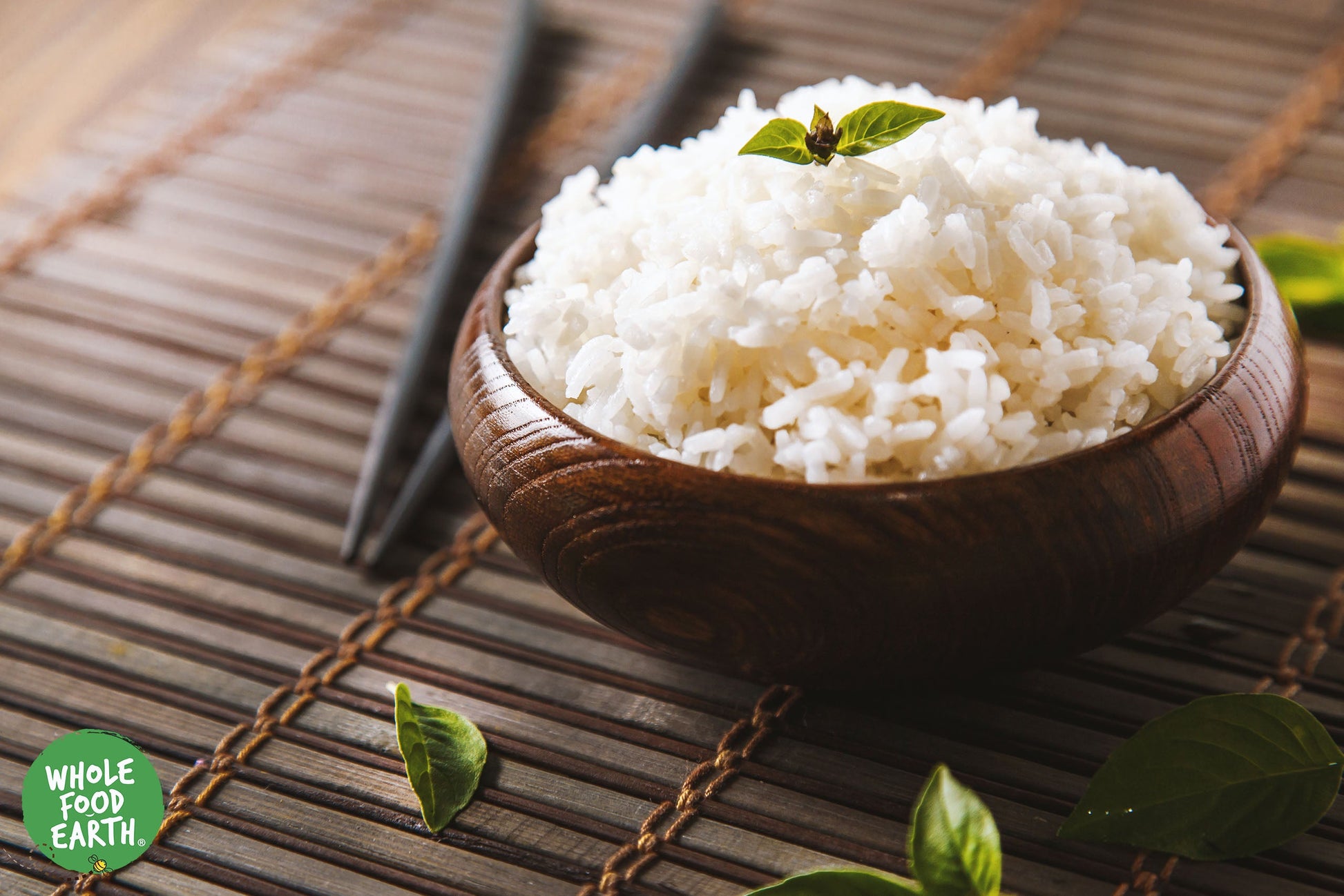 Whole Food Earth jasmine rice in a clear bag, showcasing long, fragrant grains of rice and couscous on a white background.