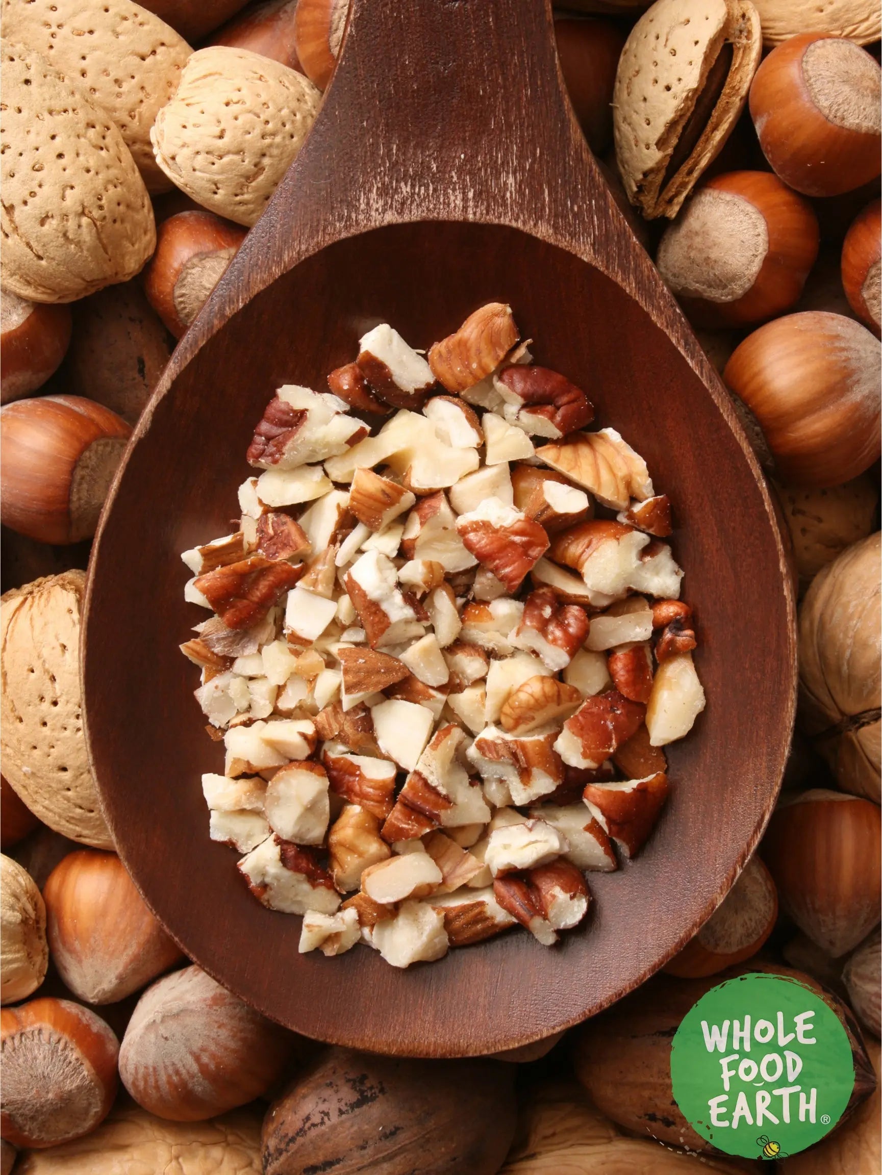 Mixed chopped nuts from Whole Food Earth in a clear bowl, showcasing a variety of chopped almonds, walnuts, and cashews.