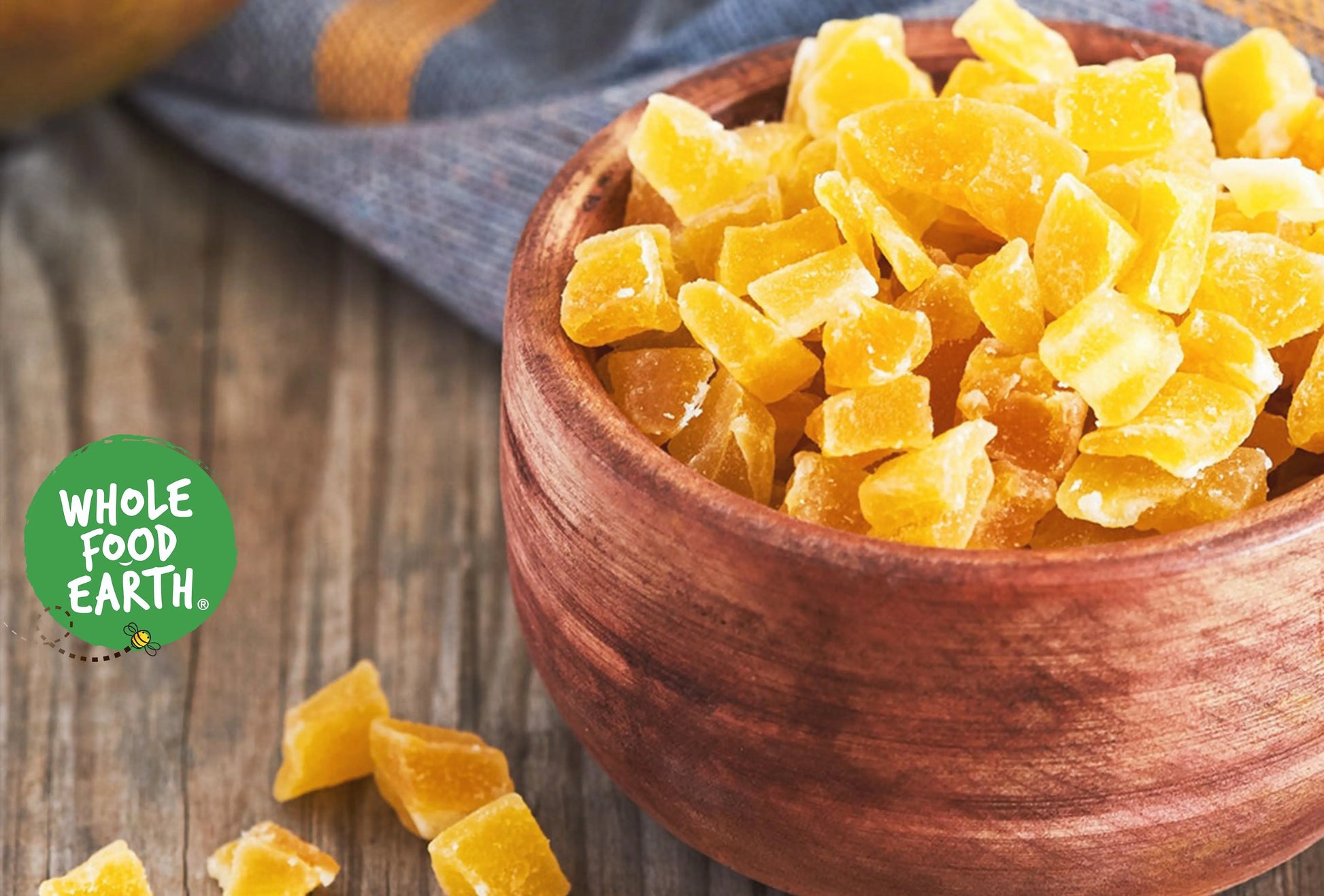 Dried mango dices from Whole Food Earth in a clear container, showcasing bright orange, bite-sized dried fruit pieces.