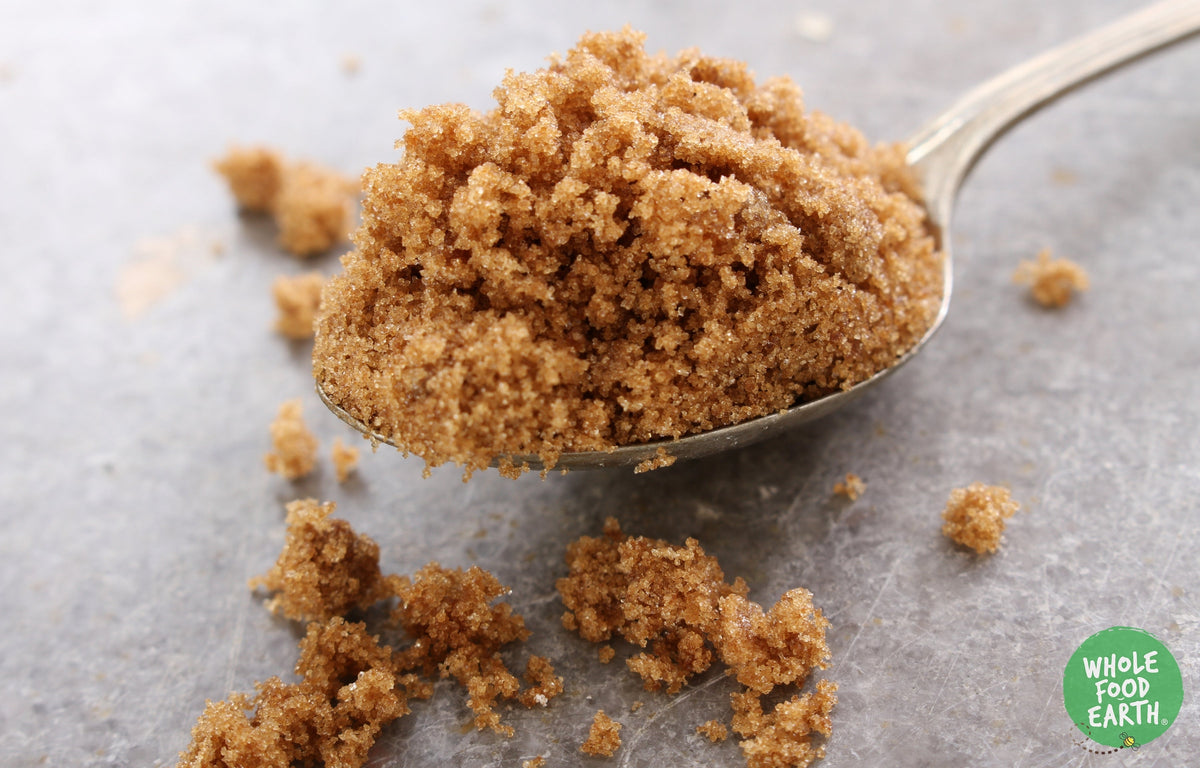Light Muscovado sugar from Whole Food Earth in a brown jar, showing the moist, granulated brown sugar close-up.