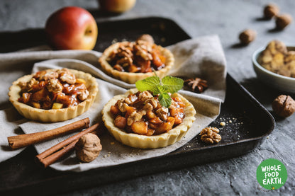 Light broken walnuts in quarters, natural nuts and seeds from Whole Food Earth, showing their light color and textured surface.
