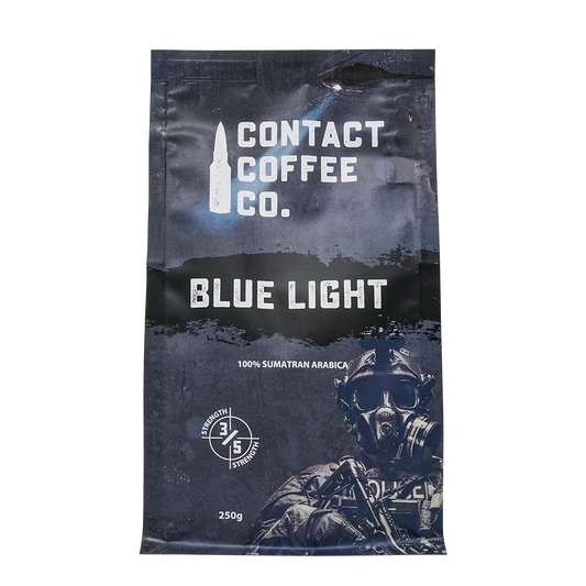 Blue Light Coffee by Contact Coffee Company Ltd., a steaming cup of coffee with a blue light logo on a rustic wooden table.