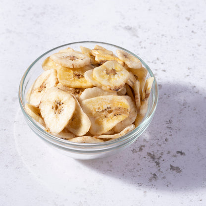 Sweetened banana chips from Whole Food Earth, dried fruit snack with golden, crispy banana slices on a white background.