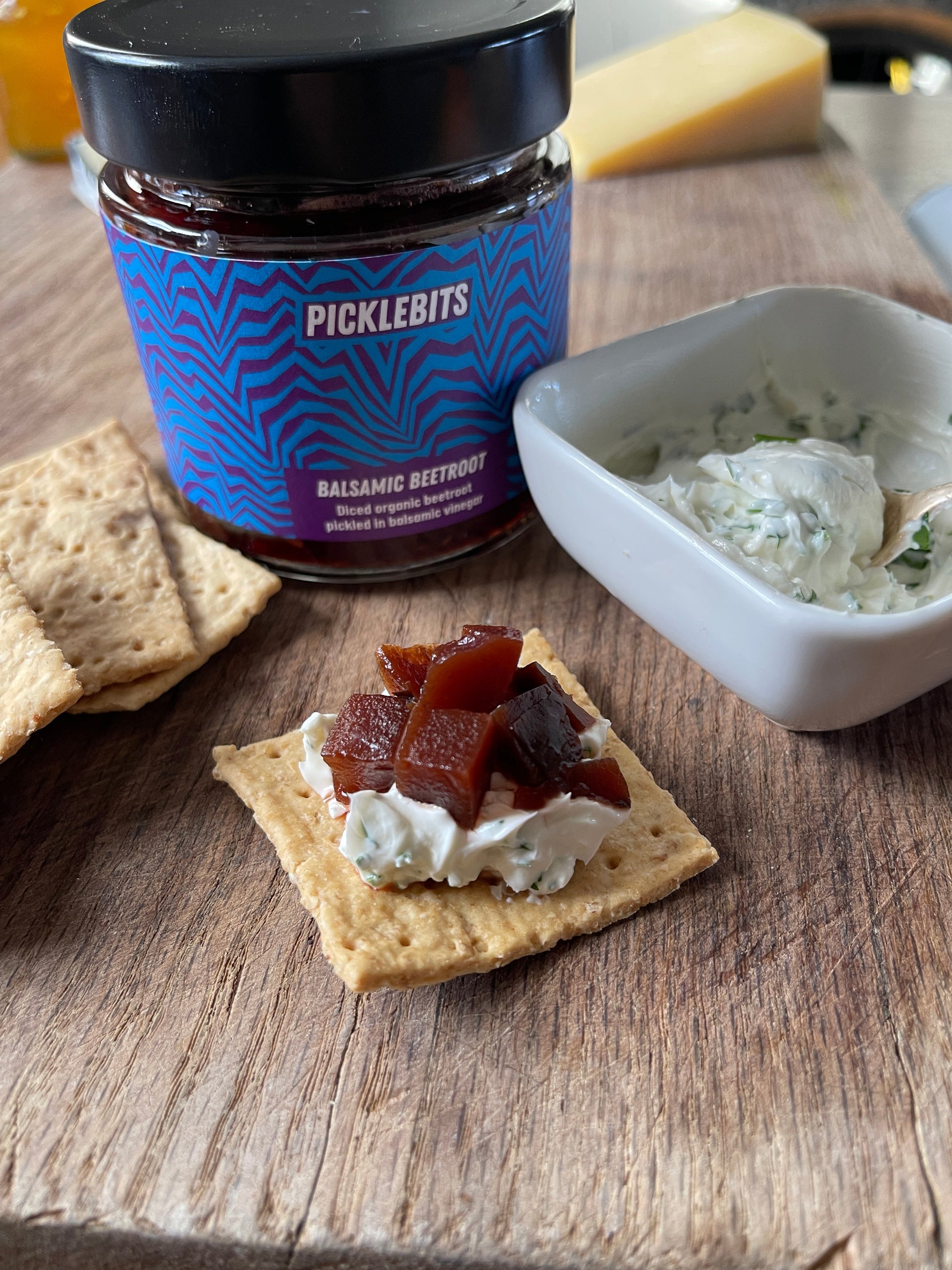 Organic chopped balsamic pickled beetroot spread on a cracker, highlighting vibrant beetroot and glossy balsamic glaze.