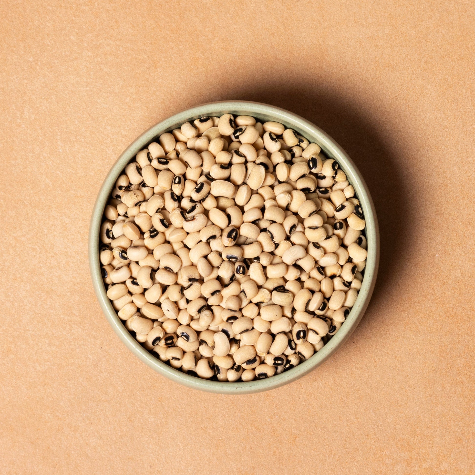 Whole Food Earth blackeye beans, fresh and raw legumes, in a close-up image showing their black and white mottled appearance.