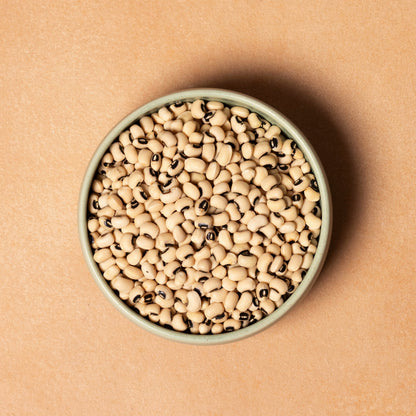 Whole Food Earth blackeye beans, fresh and raw legumes, in a close-up image showing their black and white mottled appearance.