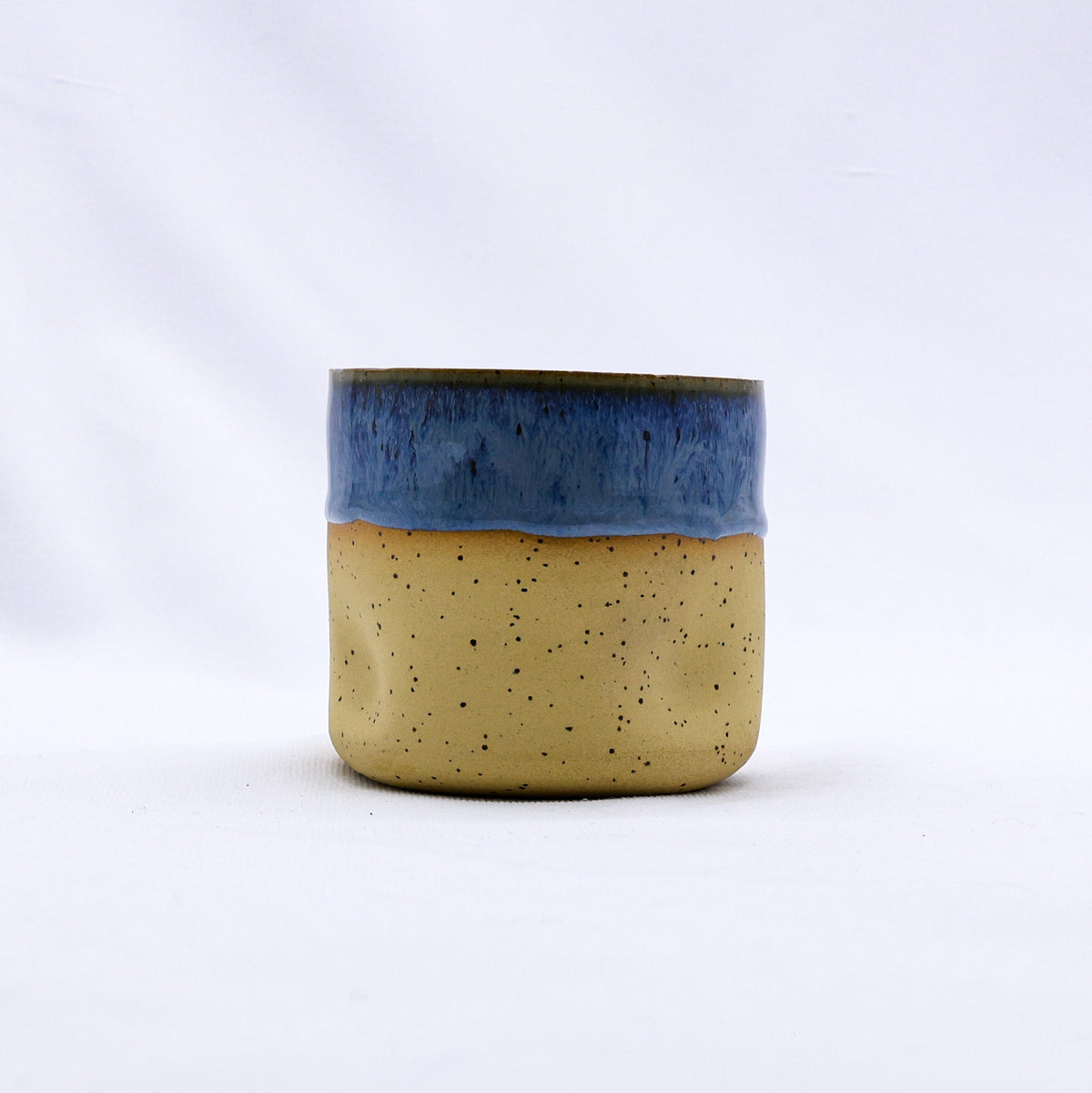 Handmade ceramic Goccia stoneware cup by Ribera Handmade Ceramics, featuring a glazed blue and white design with a smooth, rounded shape.