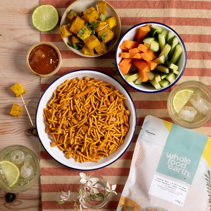 Whole Food Earth Bombay Mix featuring gram flour noodles, peas, peanuts, and lentils in a colorful snack bowl.