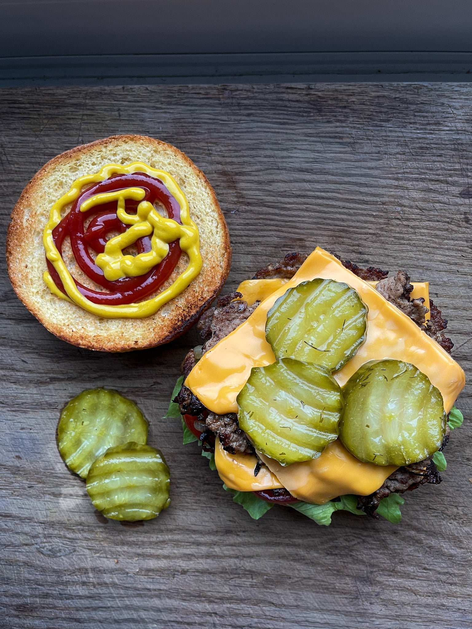 Spicy organic burger pickles from PICKLEBITS on a burger with fresh ingredients and lettuce.