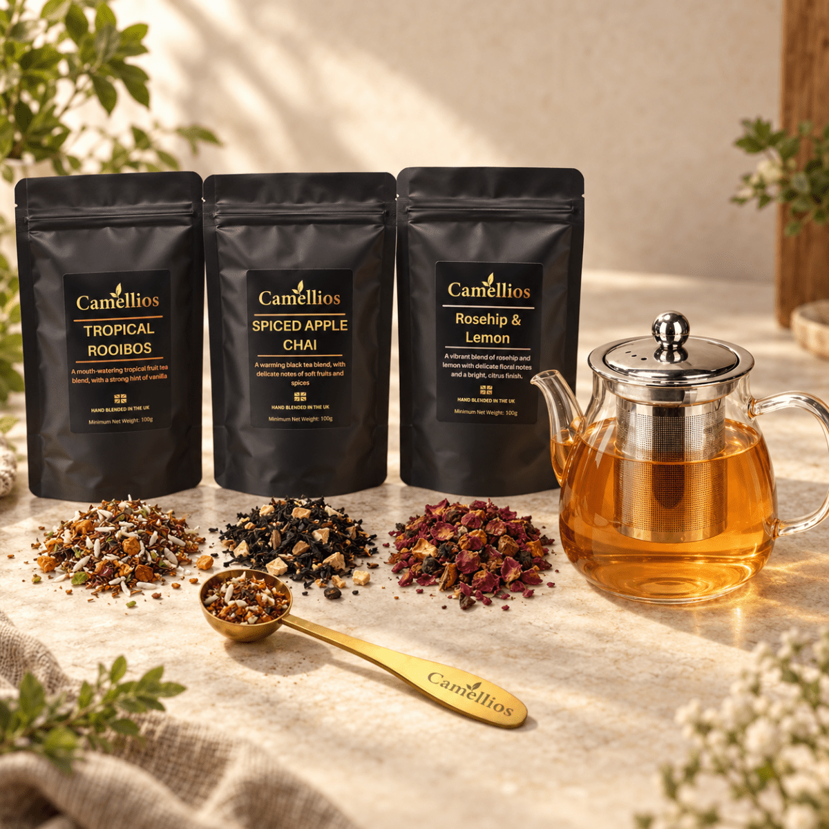 Camellios loose leaf tea set with various tea infusions, including a teapot, cups, and loose tea leaves displayed on a wooden surface.