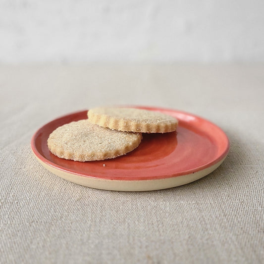 Cherry red classic cake plate by Katie L Thompson Designs, showcasing a round ceramic serving platter with a smooth finish.