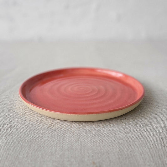 Cherry red ceramic cake plate by Katie L Thompson Designs, featuring a classic round shape and decorative edge.