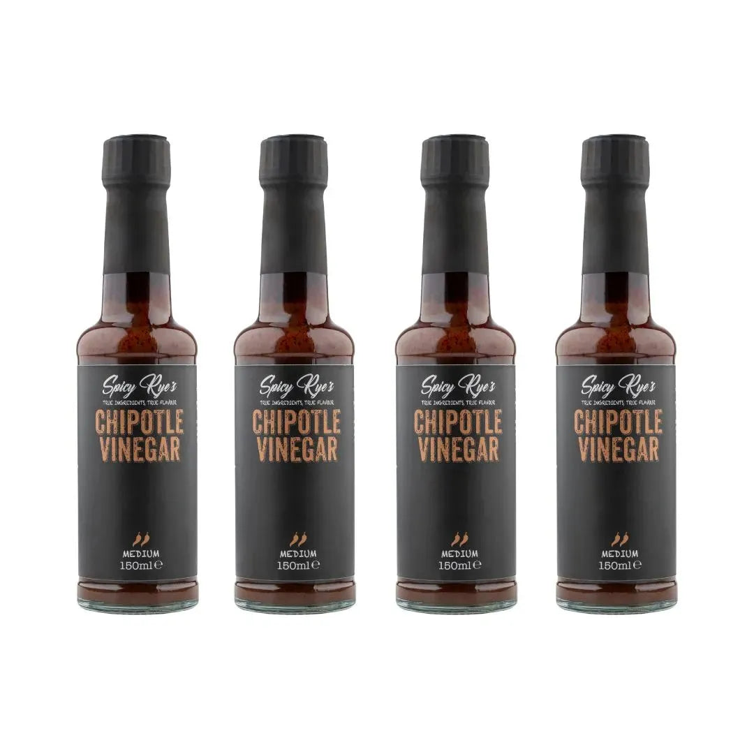 Four bottles of Spicy Ryes chipotle vinegar with dark glass bottles and red labels, used for flavorful cooking and dressings.