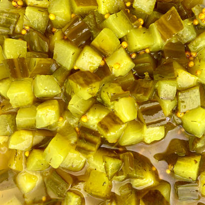 Organic chopped dill pickles in a container, showing small cucumber pieces with dill herbs, by PICKLEBITS.