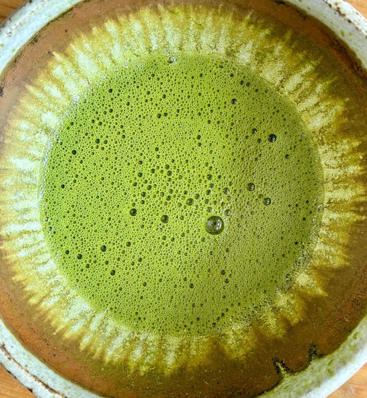 Close-up of vibrant green Izu Matcha tea in a ceramic bowl, showcasing smooth, finely ground green tea leaves from Porter Hill Tea Company.