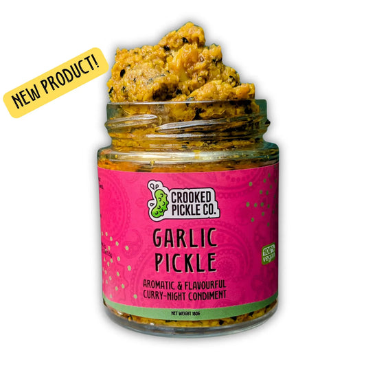 Jar of garlic pickle from Crooked Pickle Co with visible garlic cloves and spicy, tangy pickle in glass container.