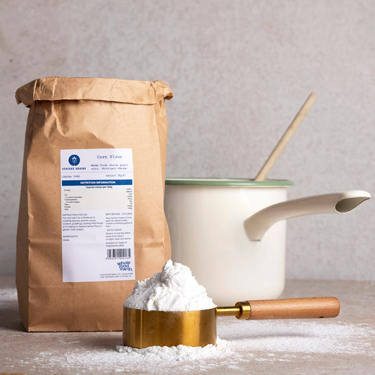 Whole Food Earth corn flour from Serious Grains, showing a bag of corn flour with a rustic kitchen background.