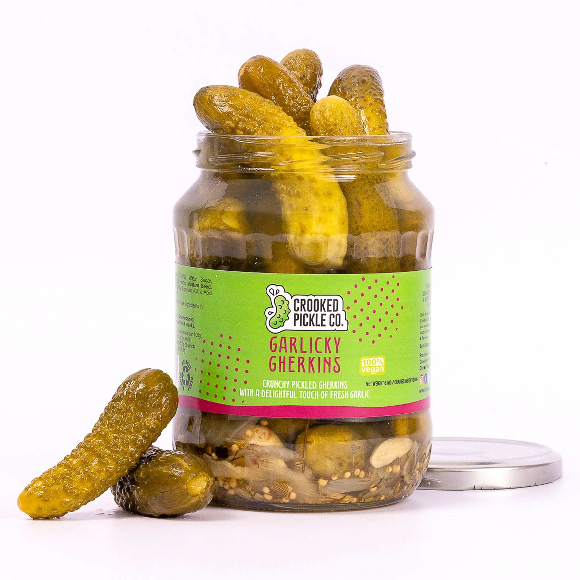 Jar of Crooked Pickle Co. Garlicky Gherkins with visible small cucumbers and garlic cloves in brine, ready to enjoy.