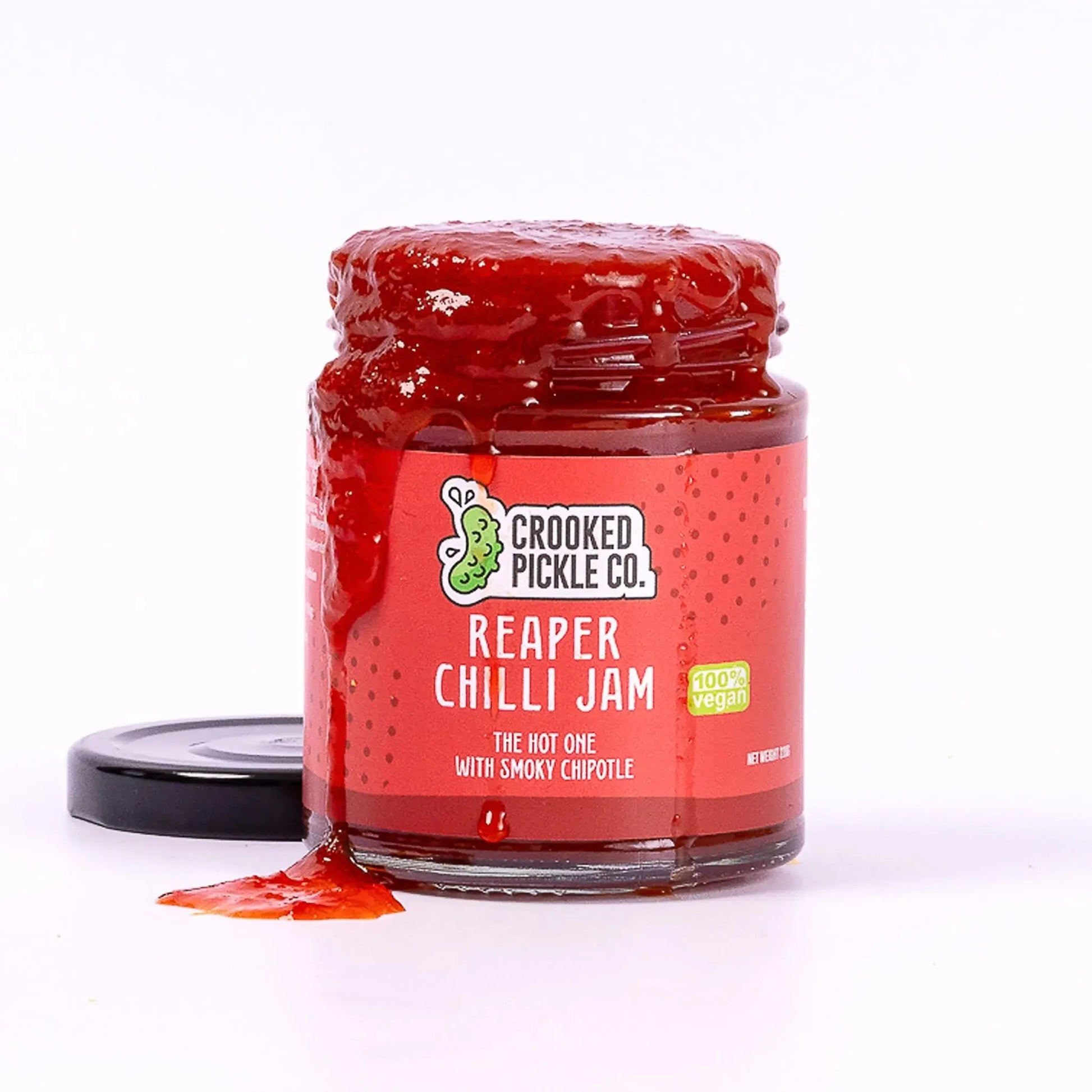 Reaper Chilli Jam jar by Crooked Pickle Co, showing the spicy chili jam in a glass jar with a label and spoon for serving.