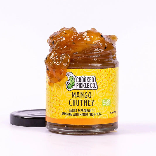 Jar of Crooked Pickle Co mango chutney with a label, showcasing the vibrant orange color and smooth texture.