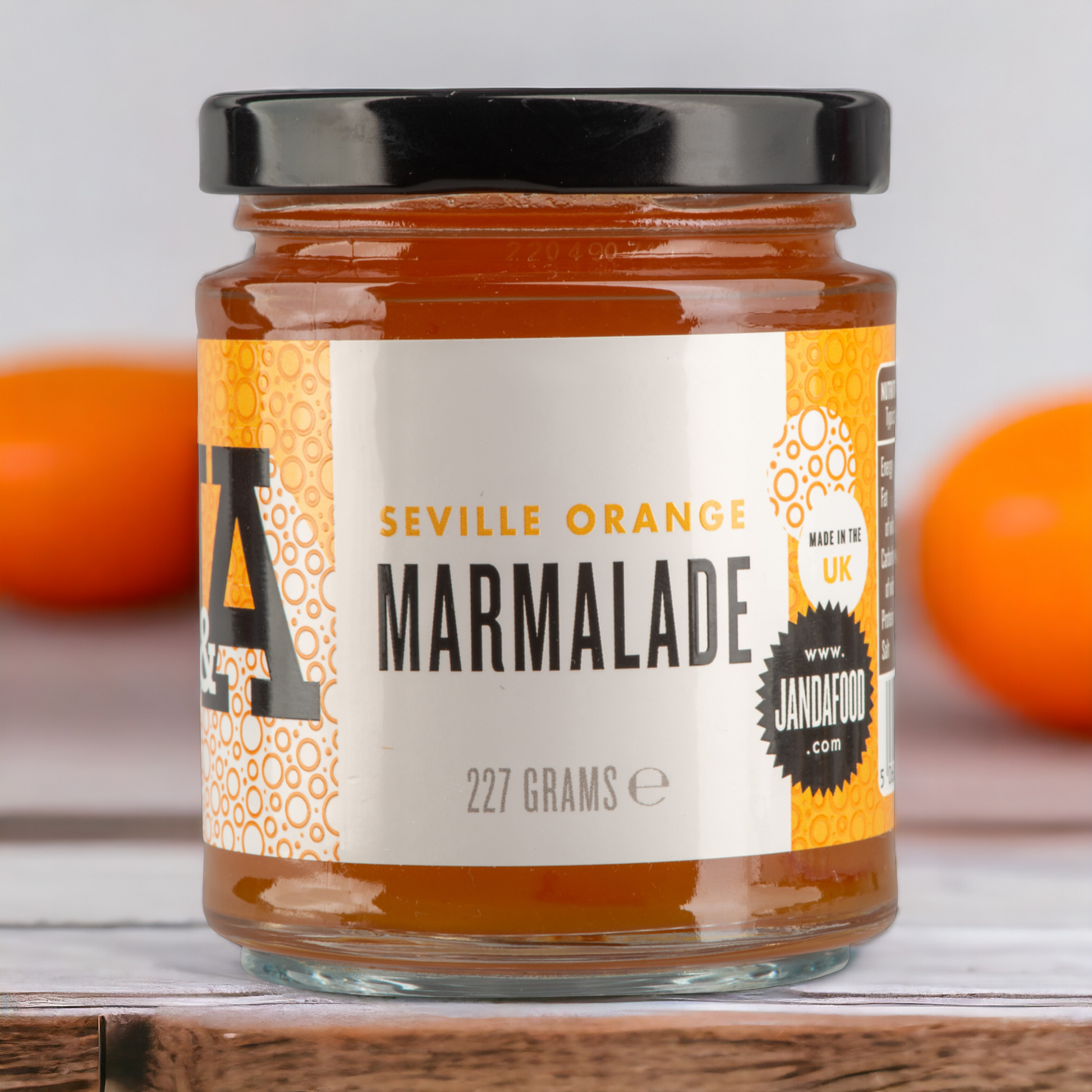 Janda Seville Orange Marmalade jar with a spread of marmalade on toast, showcasing the bright orange color and glossy texture.