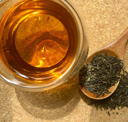 Decaf Kyushu Sencha green tea from Porter Hill Tea Company in a tea bag, showcasing vibrant green tea leaves.