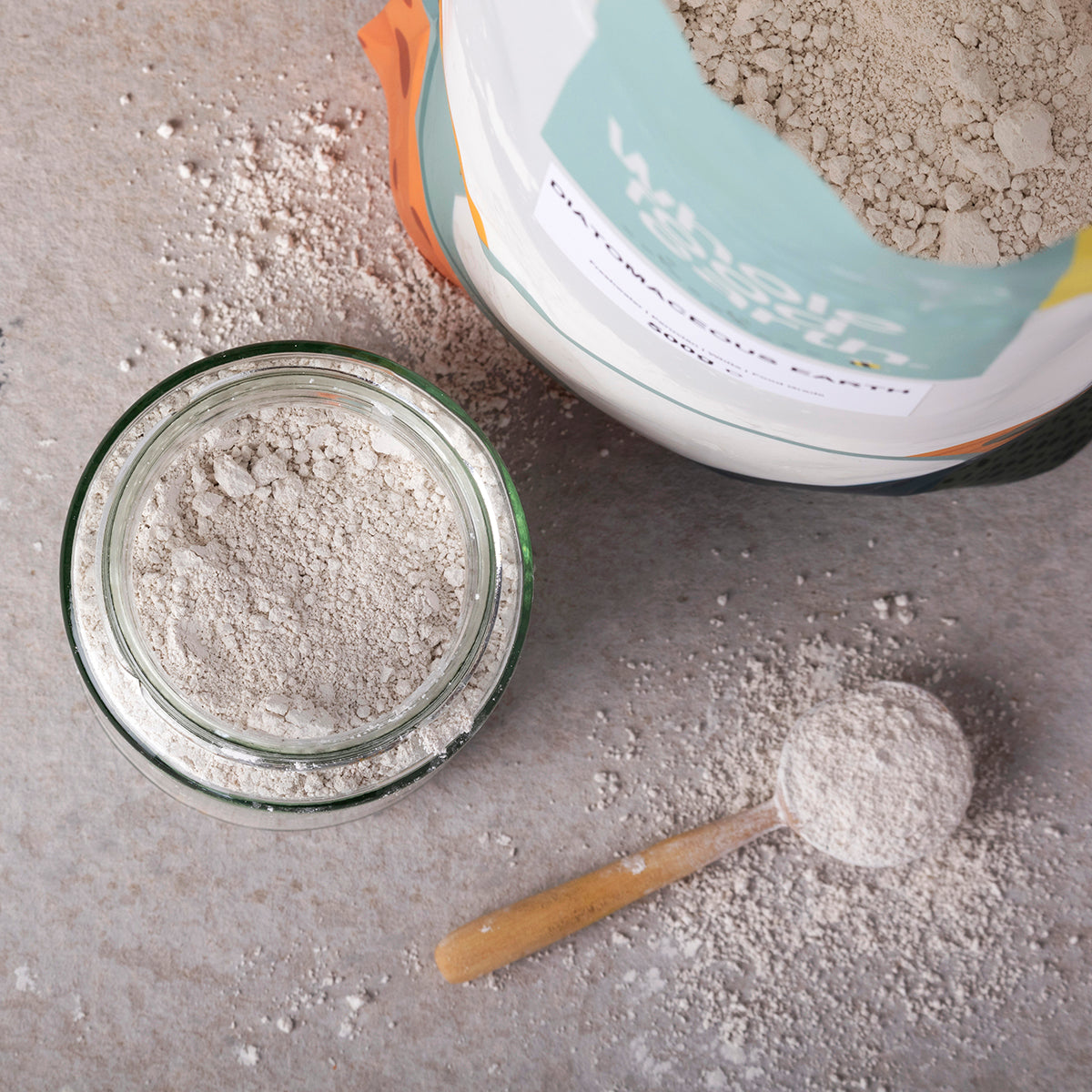 Food grade diatomaceous earth mineral from Whole Food Earth, natural powder in a lifestyle setting with a scoop and jar.