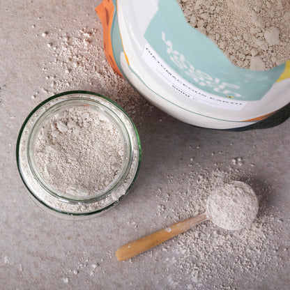 Food grade diatomaceous earth mineral from Whole Food Earth, natural powder in a lifestyle setting with a scoop and jar.