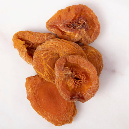 Dried peach halves from Whole Food Earth, a natural dried fruit with sweet, chewy peach slices on a white background.