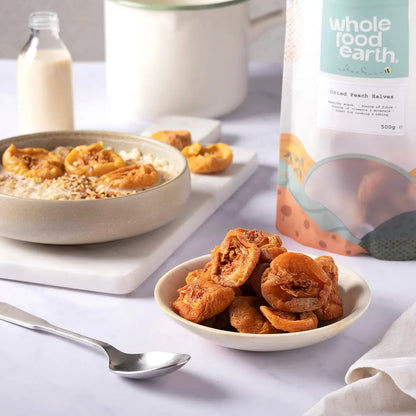 Dried peach halves from Whole Food Earth, showcasing vibrant orange dried fruit slices on a rustic wooden surface.