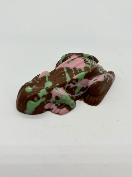 Pink and green exploding chocolate frog by Gorvett & Stone, detailed candy with vibrant colors and playful design.