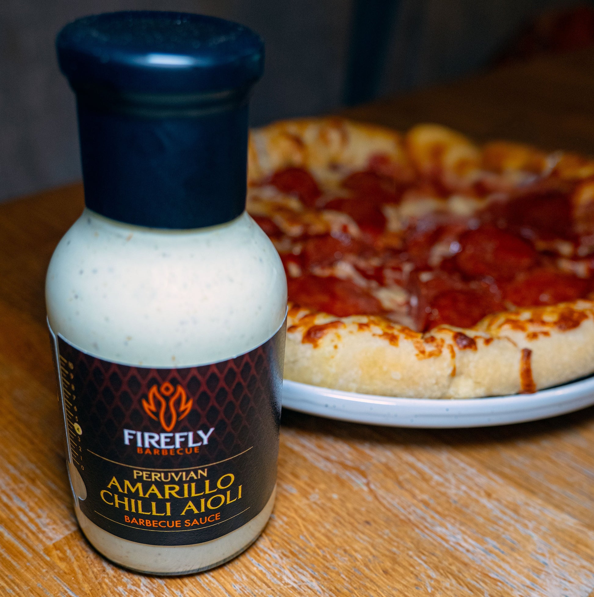 Peruvian Amarillo Chilli Aioli from FireFly Barbecue, creamy yellow sauce with spicy chili flavor, served with pizza.