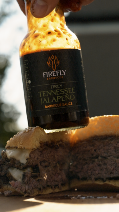 Tennessee Jalapeno BBQ Sauce by FireFly Barbecue shown on a burger with jalapenos and smoky barbecue flavor