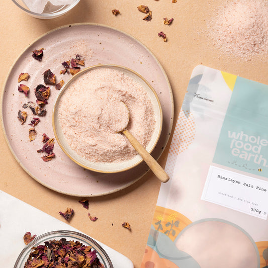 Fine Himalayan Salt crystals from Whole Food Earth, shown in a natural setting with salt in a glass jar and surrounding minerals.